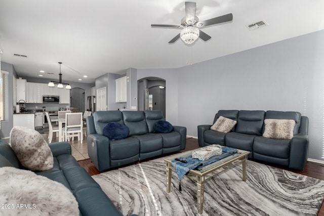 living room with sink, hardwood / wood-style flooring, and ceiling fan