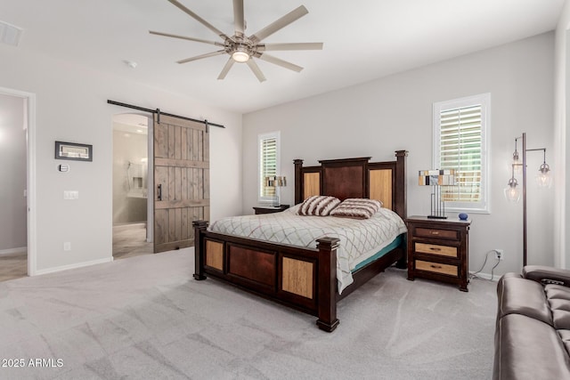 bedroom with a barn door, light carpet, ceiling fan, connected bathroom, and baseboards