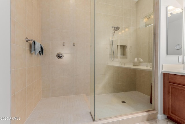 full bath featuring tiled shower and vanity