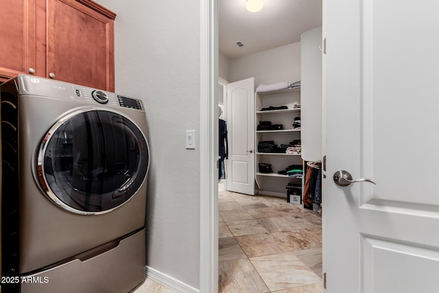 clothes washing area featuring washer / dryer, visible vents, and cabinet space