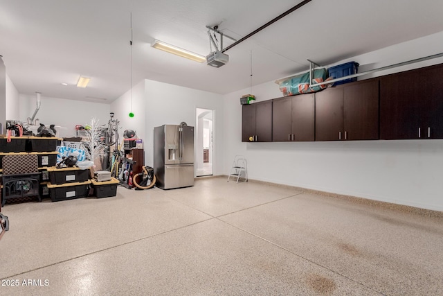 garage featuring stainless steel fridge and a garage door opener