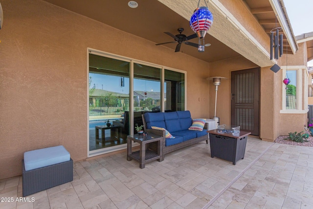 view of patio with a ceiling fan and an outdoor living space with a fire pit