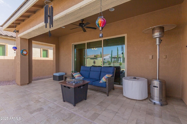 view of patio featuring a ceiling fan, fence, and an outdoor living space