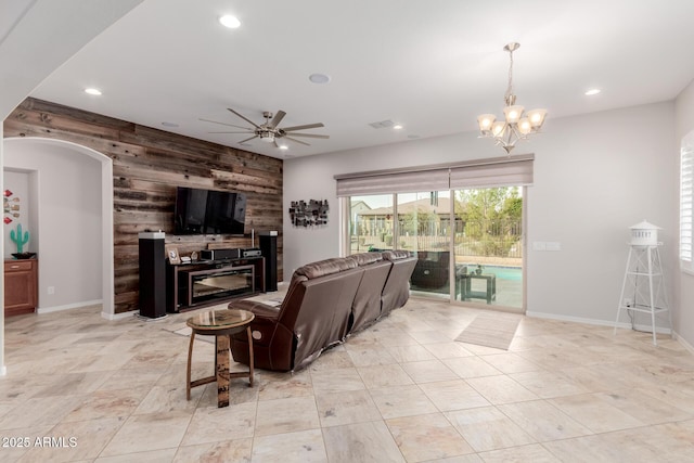 living room featuring wood walls, an accent wall, and recessed lighting