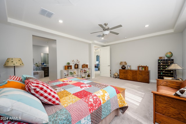 carpeted bedroom with a raised ceiling and ceiling fan