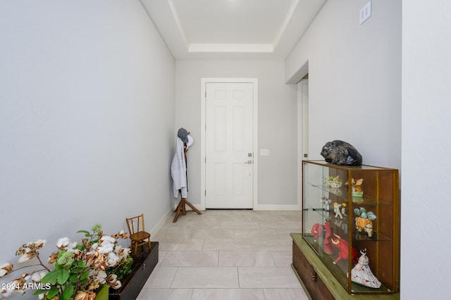 tiled entrance foyer featuring a tray ceiling