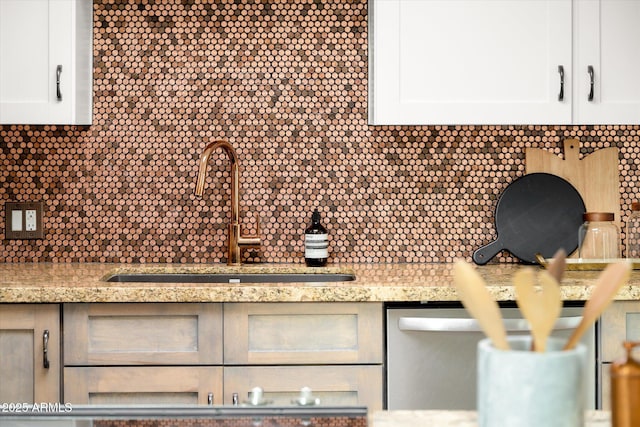 room details with sink, backsplash, light stone countertops, white cabinets, and stainless steel dishwasher