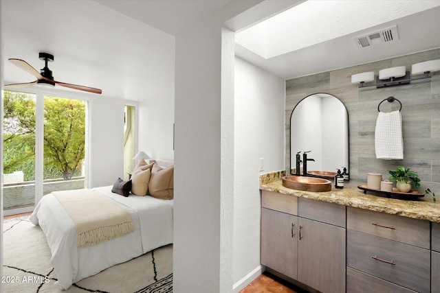 bathroom featuring ceiling fan, vanity, and a skylight