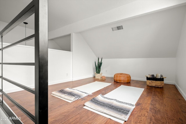 workout area with hardwood / wood-style flooring and vaulted ceiling