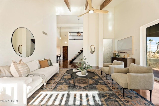 living room featuring beam ceiling and a towering ceiling