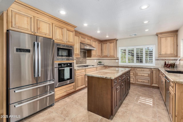 kitchen featuring light stone counters, appliances with stainless steel finishes, sink, and backsplash