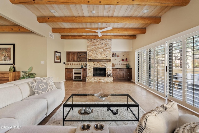 living room featuring wooden ceiling, a large fireplace, light tile patterned floors, and wine cooler