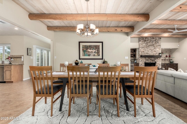 tiled dining area with beamed ceiling, a notable chandelier, wood ceiling, and a fireplace