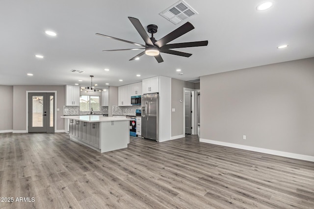 kitchen featuring light countertops, open floor plan, visible vents, and stainless steel appliances