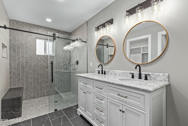 bathroom featuring a sink, tiled shower, and double vanity