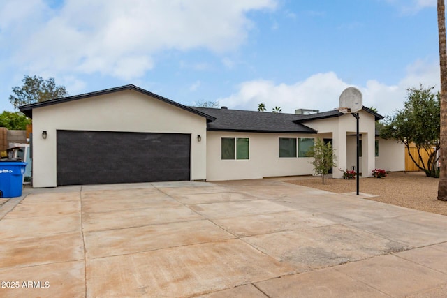 ranch-style house with stucco siding, a garage, and concrete driveway