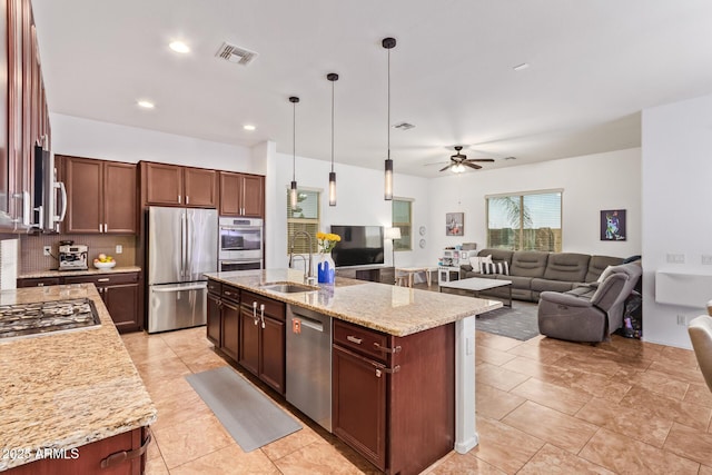 15862 W Fillmore St, Goodyear, AZ 85338 - kitchen with appliances with stainless steel finishes, a sink, a ceiling fan, open floor plan, and backsplash