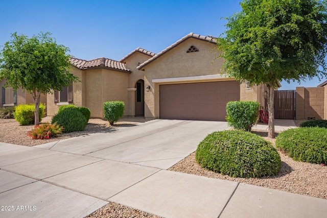15862 W Fillmore St, Goodyear, AZ 85338 - mediterranean / spanish-style home featuring a garage, stucco siding, driveway, a gate, and a tiled roof
