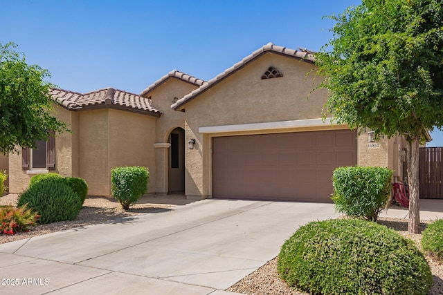15862 W Fillmore St, Goodyear, AZ 85338 - mediterranean / spanish house featuring a garage, stucco siding, concrete driveway, and a tiled roof