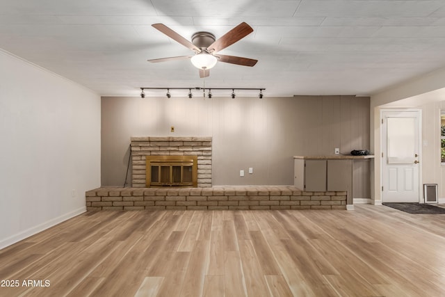 6009 W Medlock Dr, Glendale, AZ 85301 - unfurnished living room with rail lighting, wood finished floors, a brick fireplace, a ceiling fan, and ornamental molding