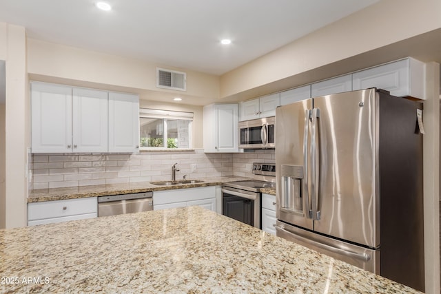 6009 W Medlock Dr, Glendale, AZ 85301 - kitchen featuring stainless steel appliances, white cabinets, backsplash, light stone countertops, and recessed lighting