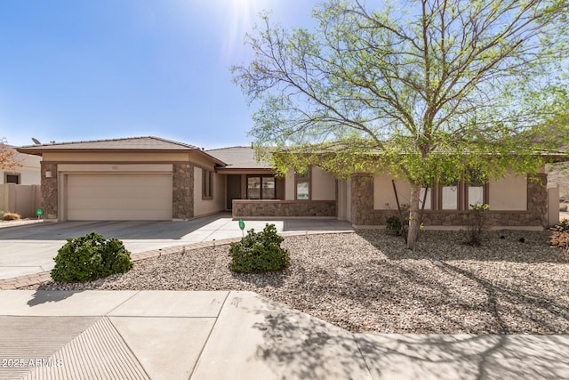 view of front of house featuring an attached garage, stone siding, concrete driveway, and stucco siding