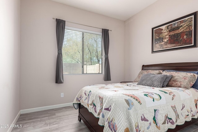 bedroom with wood finished floors and baseboards