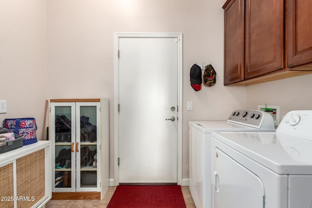 washroom featuring washing machine and clothes dryer and cabinet space