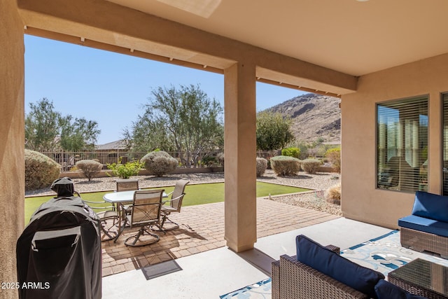 view of patio / terrace with a fenced backyard, a mountain view, and outdoor dining space