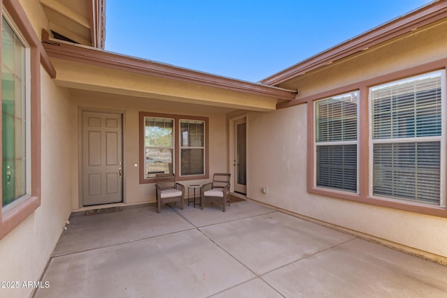 property entrance featuring covered porch and stucco siding