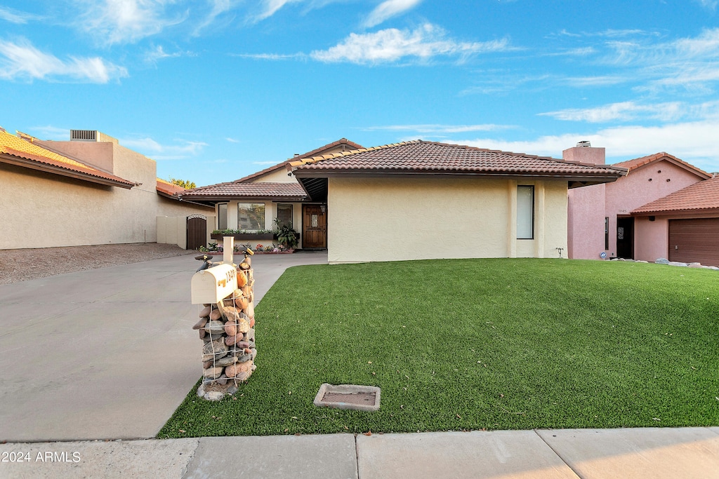 mediterranean / spanish house with a front lawn, a patio area, and a garage