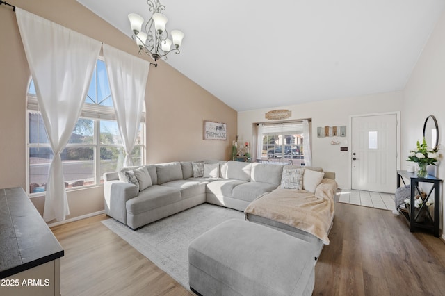 living room featuring a chandelier, high vaulted ceiling, and wood-type flooring