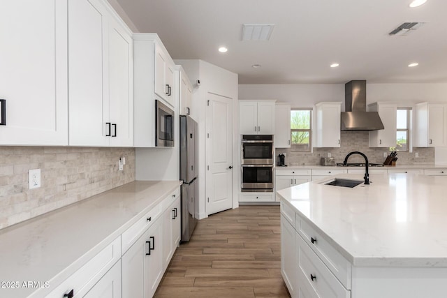 6356 S Granite St, Gilbert, AZ 85298 - kitchen featuring wall chimney exhaust hood, stainless steel appliances, decorative backsplash, light wood finished floors, and recessed lighting