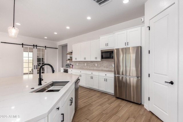 6356 S Granite St, Gilbert, AZ 85298 - kitchen featuring stainless steel appliances, a sink, light countertops, tasteful backsplash, and light wood finished floors