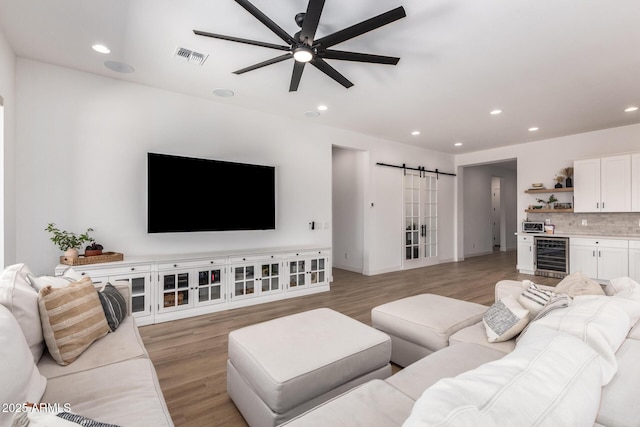 6356 S Granite St, Gilbert, AZ 85298 - living area featuring wine cooler, a barn door, light wood-style floors, ceiling fan, and recessed lighting