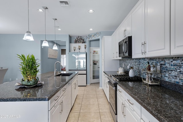 kitchen with decorative light fixtures, sink, white cabinets, a kitchen island with sink, and white appliances