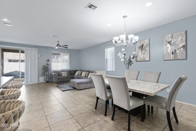 dining room featuring ceiling fan with notable chandelier and light tile patterned flooring