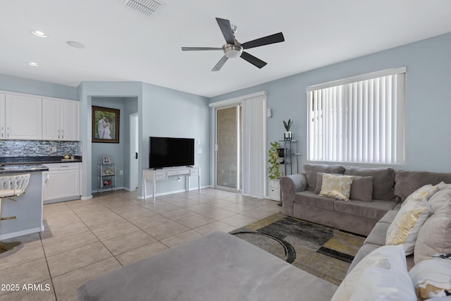 tiled living room with ceiling fan