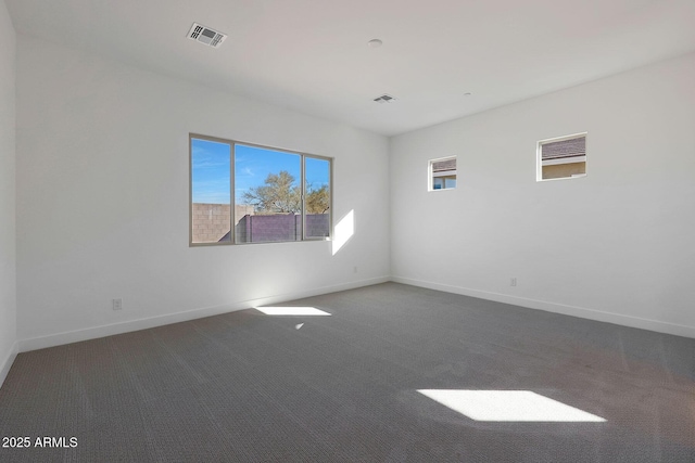 unfurnished room featuring dark carpet