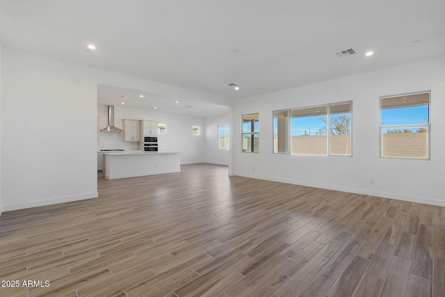 unfurnished living room with light hardwood / wood-style floors and plenty of natural light