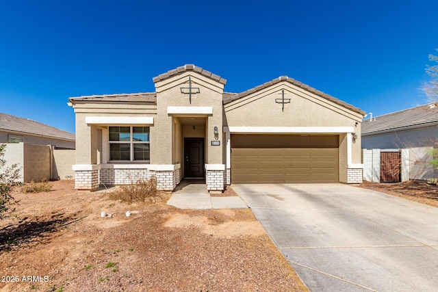 view of front of home featuring a tile roof, stucco siding, an attached garage, fence, and driveway