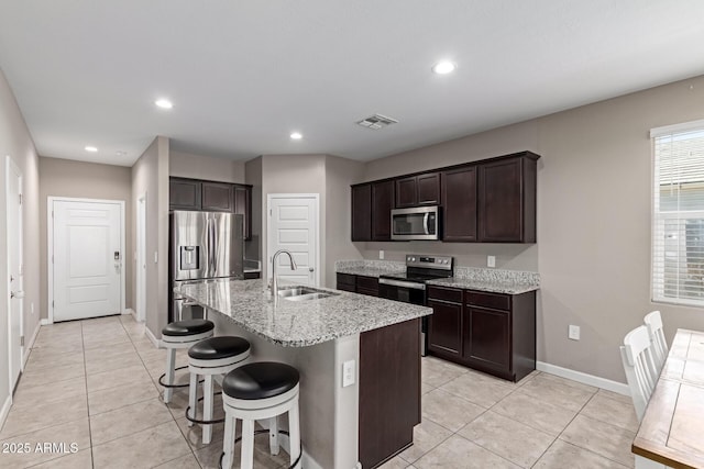 18800 W Madison St, Buckeye, AZ 85326 - kitchen featuring light stone counters, stainless steel appliances, visible vents, a sink, and dark brown cabinetry