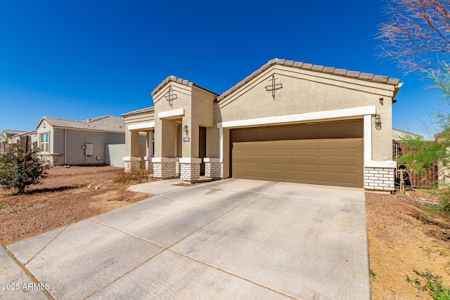 mediterranean / spanish-style house with driveway, brick siding, an attached garage, and stucco siding