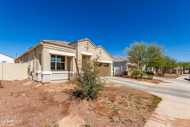 view of front of home with an attached garage, fence, concrete driveway, a tiled roof, and stucco siding