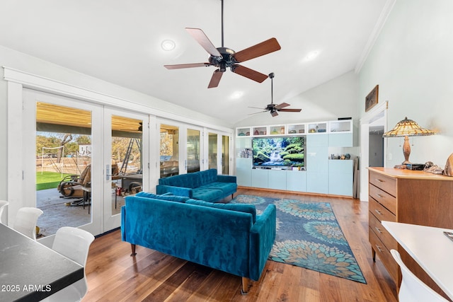 living room with ornamental molding, vaulted ceiling, wood finished floors, and french doors