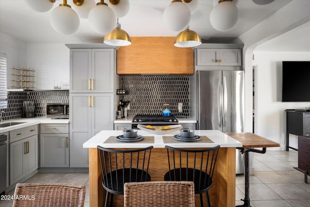 kitchen with gray cabinets, a center island, and backsplash