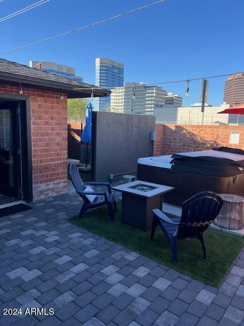 view of patio featuring a hot tub and an outdoor fire pit