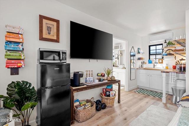 living room with light wood-type flooring and an AC wall unit