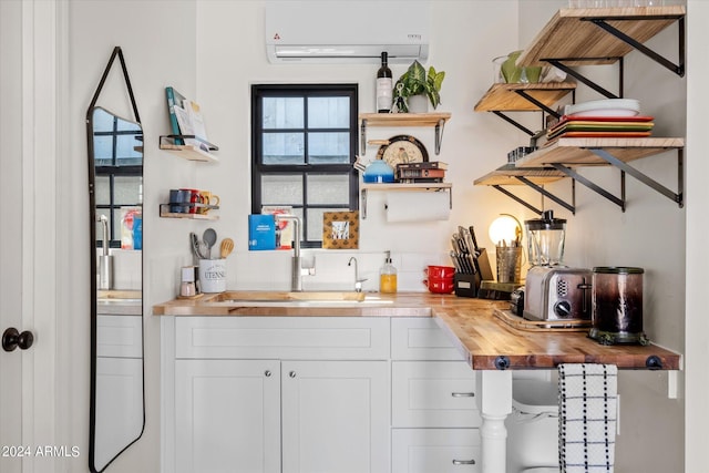 bar with a wall unit AC, white cabinetry, sink, and wood counters