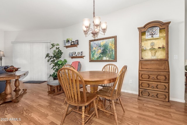 dining space featuring light hardwood / wood-style flooring and an inviting chandelier